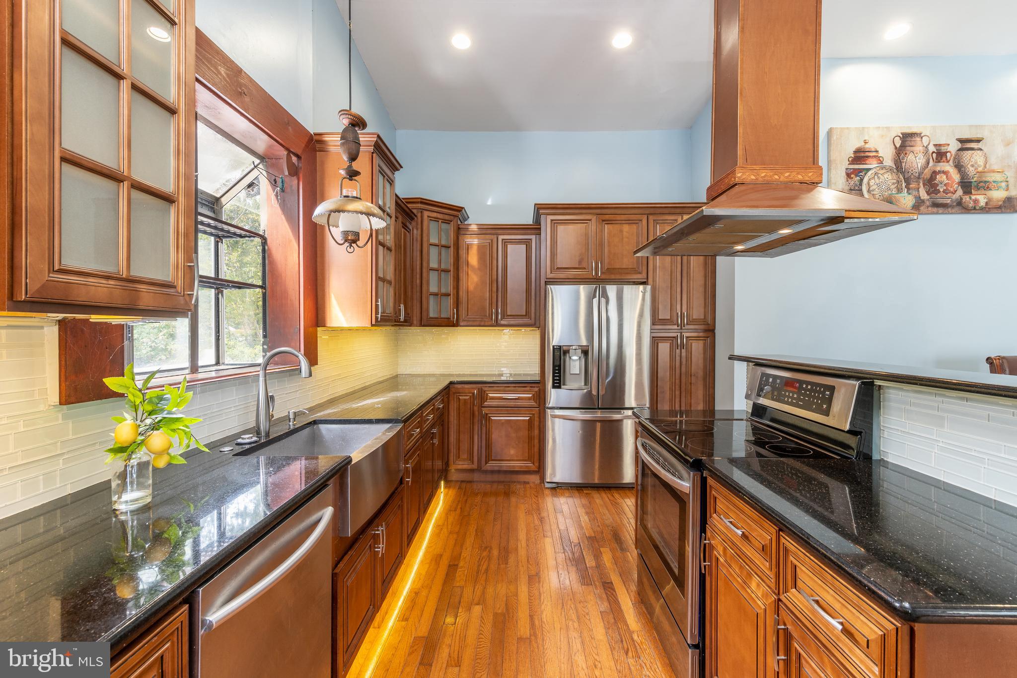 a kitchen with stainless steel appliances granite countertop a sink and wooden cabinets