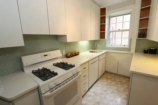 a kitchen with a stove a sink a refrigerator and window