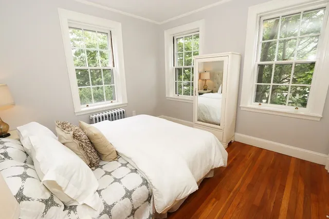 a large bed sitting in a bedroom next to a window