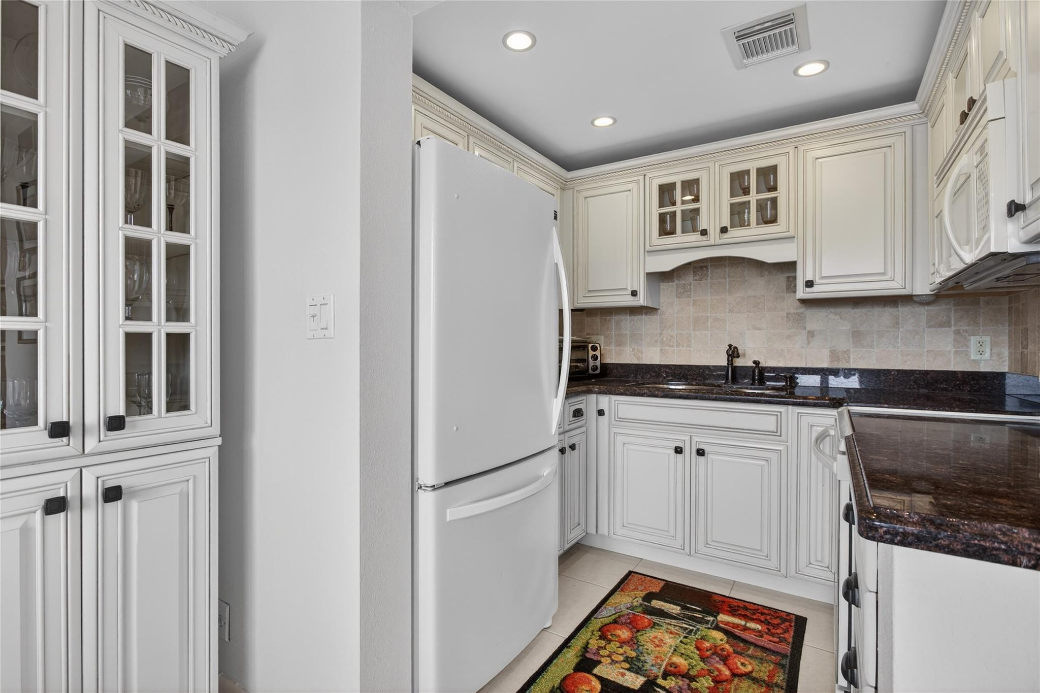 1001 North Riverside Drive, Unit 305 Pompano Beach, FL 33062 - Photo 18 of 44 a kitchen with stainless steel appliances granite countertop a refrigerator sink and white cabinets