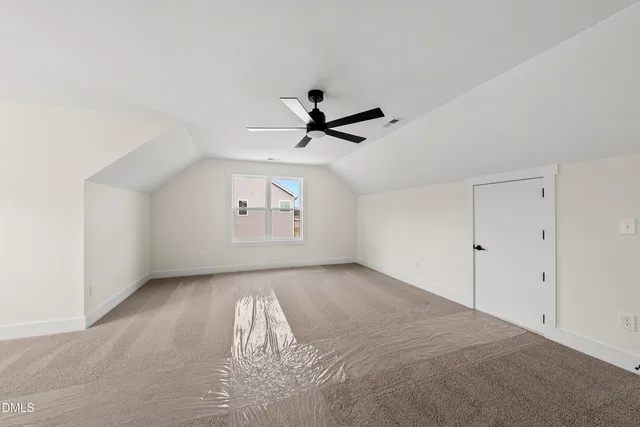 an empty room with windows and ceiling fan
