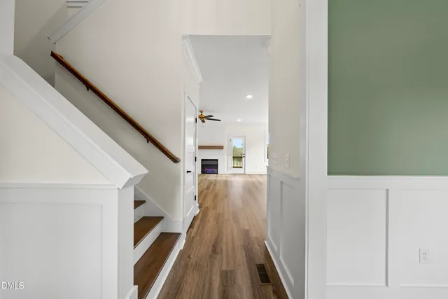 a view of a hallway with wooden floor and staircase