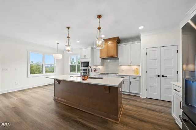 a kitchen with stainless steel appliances granite countertop a sink a stove and a refrigerator