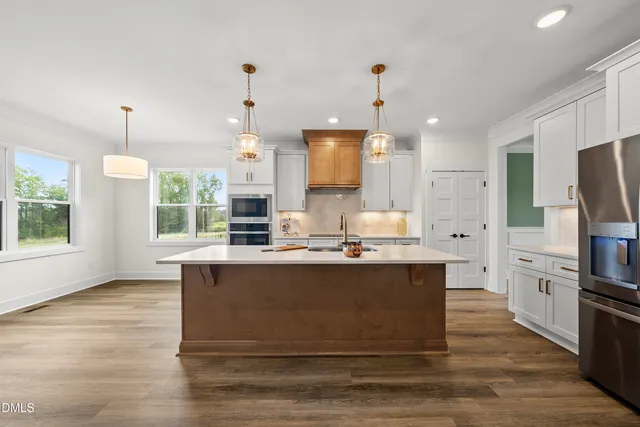 a view of kitchen with stainless steel appliances granite countertop stove top oven and refrigerator