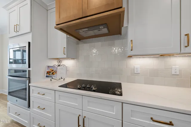 a kitchen with white cabinets and sink