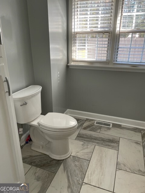 839 Sandy Creek Road Fayetteville, GA 30214 - Photo 13 of 22 a bathroom with a toilet a sink and a window
