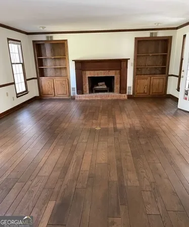 an empty room with wooden floor and fireplace
