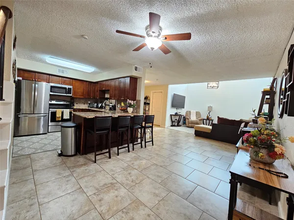 a living room with lots of furniture and kitchen view