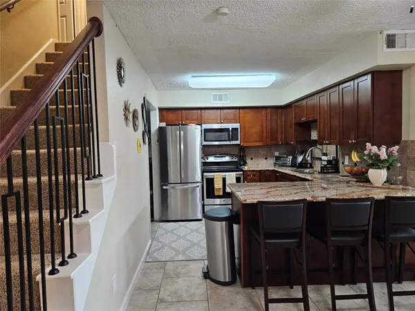 a kitchen with appliances cabinets and furniture