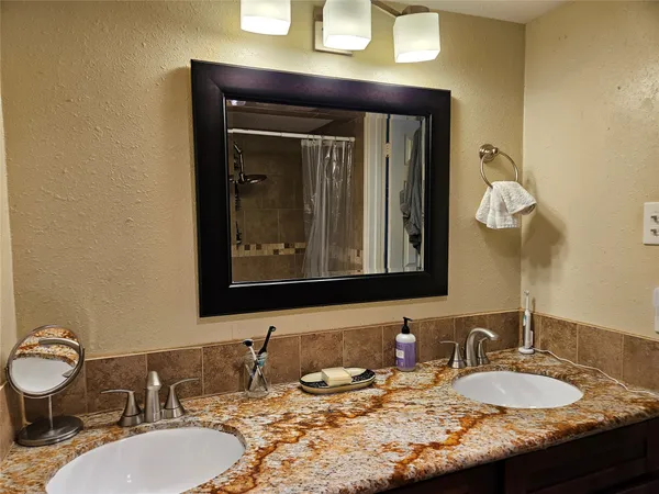 a bathroom with a granite countertop sink a mirror and