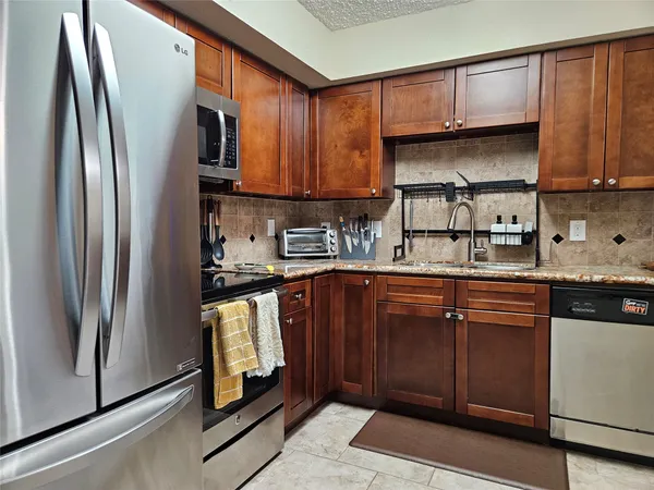 a kitchen with stainless steel appliances granite countertop a refrigerator sink and cabinets