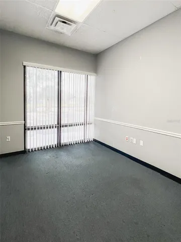 a view of a building with a potted plant and floor to ceiling window