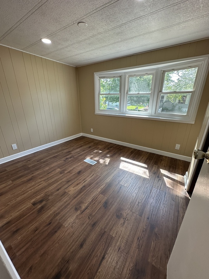 180 North Windmere Circle Matteson, IL 60443 - Photo 18 of 32 a view of an empty room with wooden floor and a window