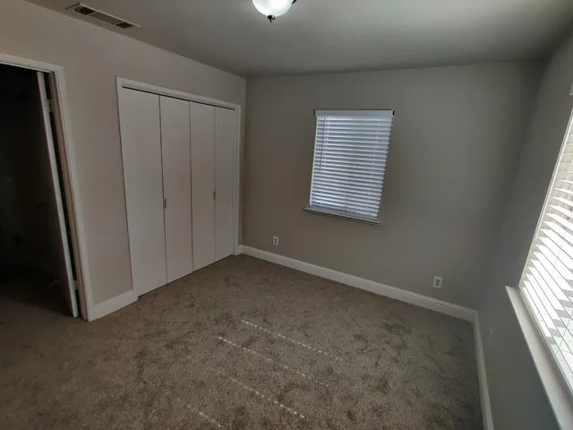 a view of a hallway with white walls and door