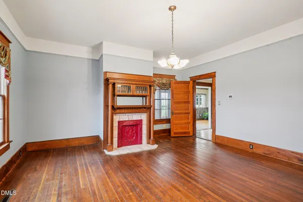 a dining room with furniture a chandelier and wooden floor