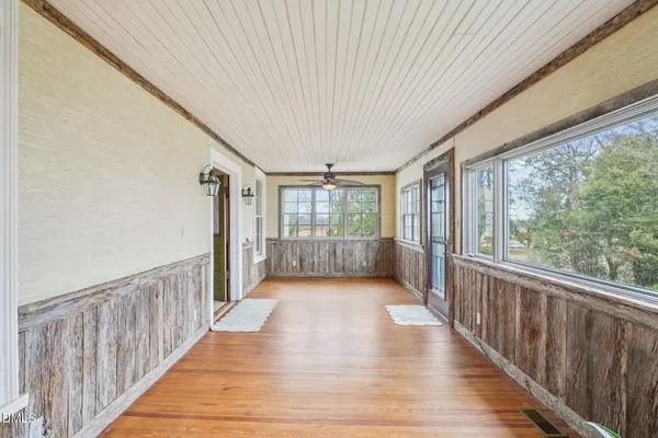 a view of a hallway with wooden floor and staircase