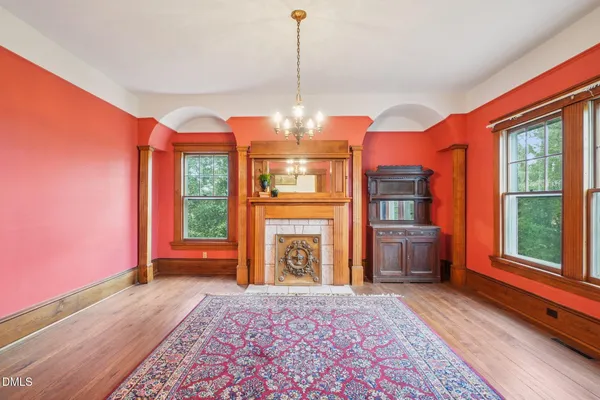 a view of an empty room with window and wooden floor