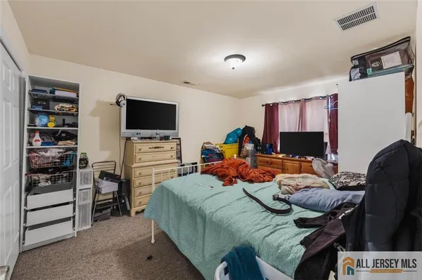 a bedroom with furniture and a flat screen tv