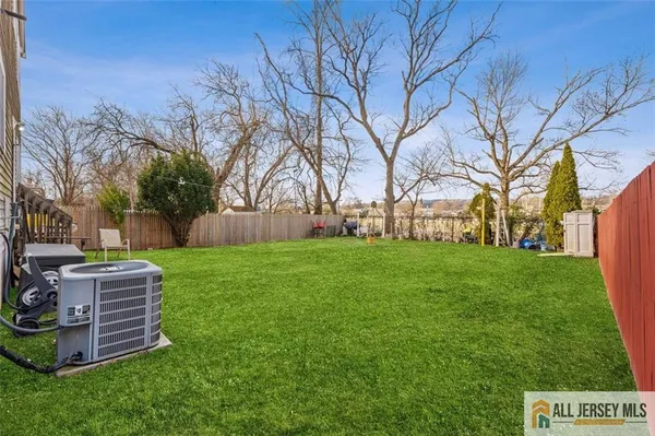 a view of backyard with wooden fence