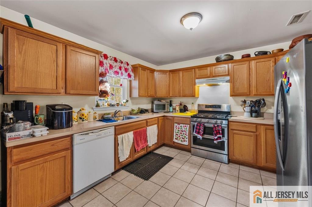 643 Drake Avenue Middlesex, NJ 08846 - Photo 10 of 28 a kitchen with stainless steel appliances granite countertop a refrigerator sink and cabinets