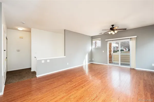 a view of an empty room with window and wooden floor