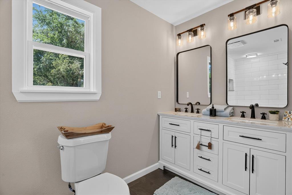 130 R And R Drive Springtown, TX 76082 - Photo 20 of 40 Dual vanity with white cabinetry and dark hardware, set against light-toned walls
