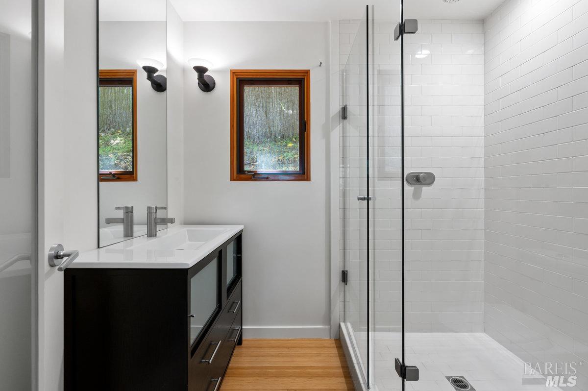 216 Reed Street Mill Valley, CA 94941 - Photo 8 of 17 a bathroom with a granite countertop sink a mirror and shower