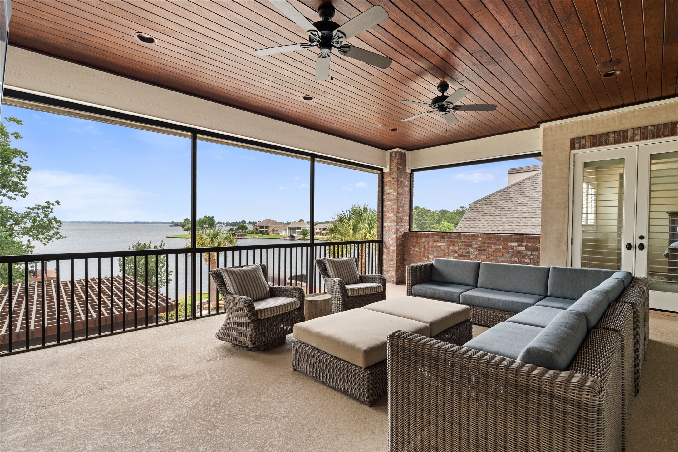 12349 Longmire Trace Conroe, TX 77304 - Photo 32 of 48 Screened-in lakeside patio with wood-plank ceiling, dual fans, and panoramic water views.