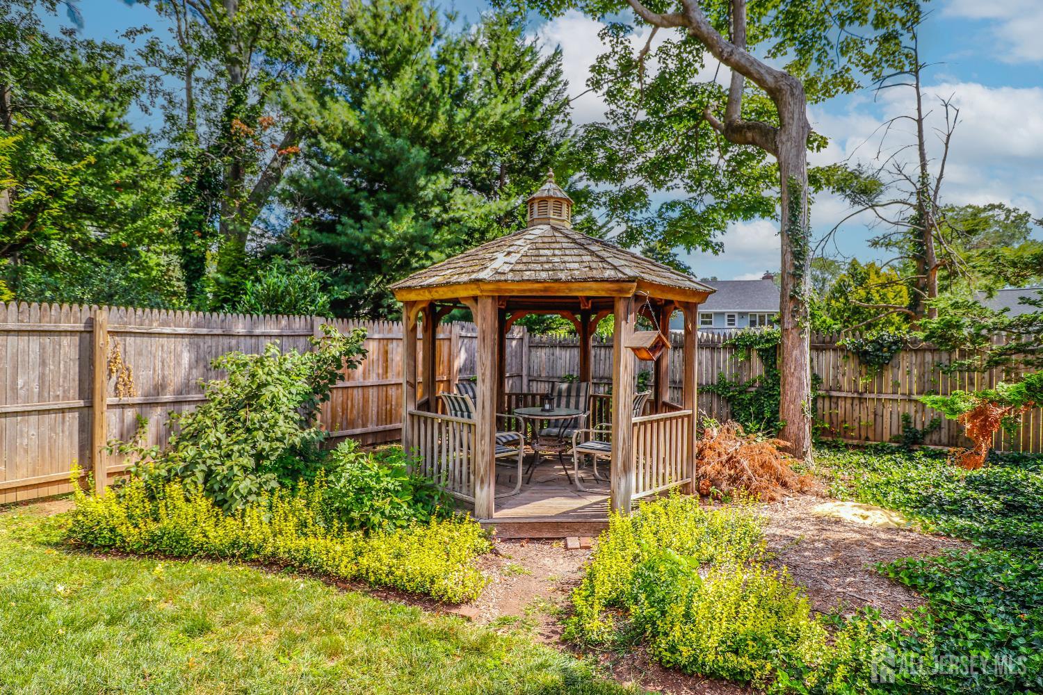 12 Buchanan Road Metuchen, NJ 08840 - Photo 27 of 42 a patio with wooden table and chairs