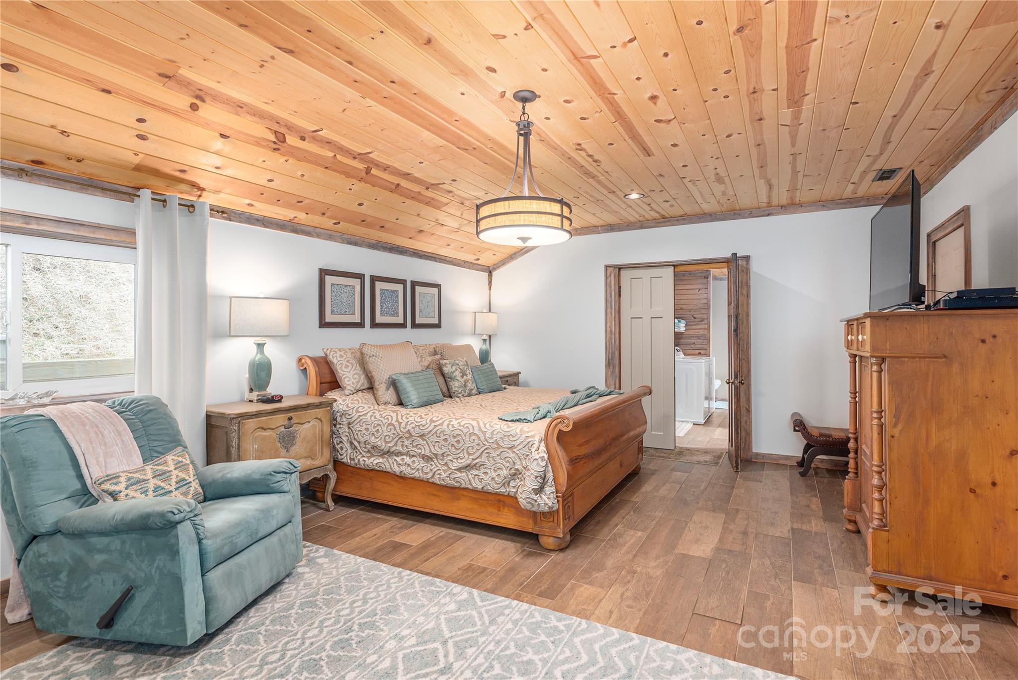 1202 Iron Duff Road Waynesville, NC 28785 - Photo 23 of 42 a spacious bedroom with a bed couch and a window