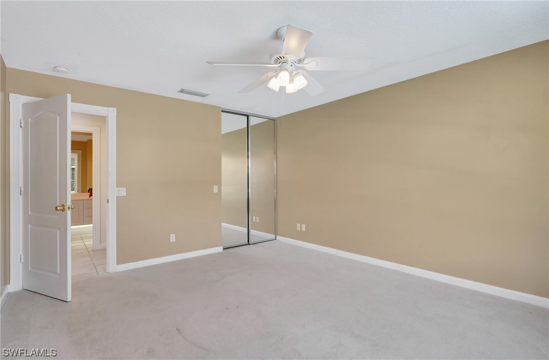 5682 Eleuthera Way Naples, FL 34119 - Photo 12 of 47 a view of an empty room with a chandelier fan