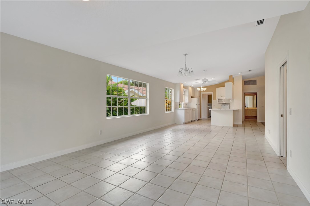 5682 Eleuthera Way Naples, FL 34119 - Photo 13 of 47 an empty room with windows and chandelier