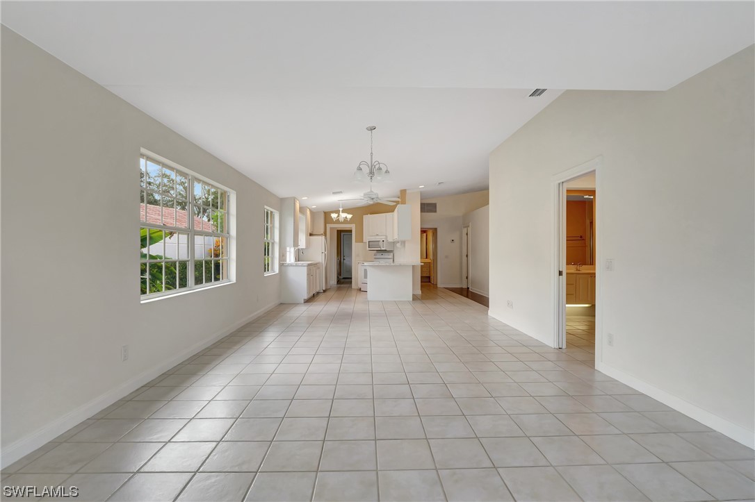5682 Eleuthera Way Naples, FL 34119 - Photo 14 of 47 a view of an empty room with window and chandelier