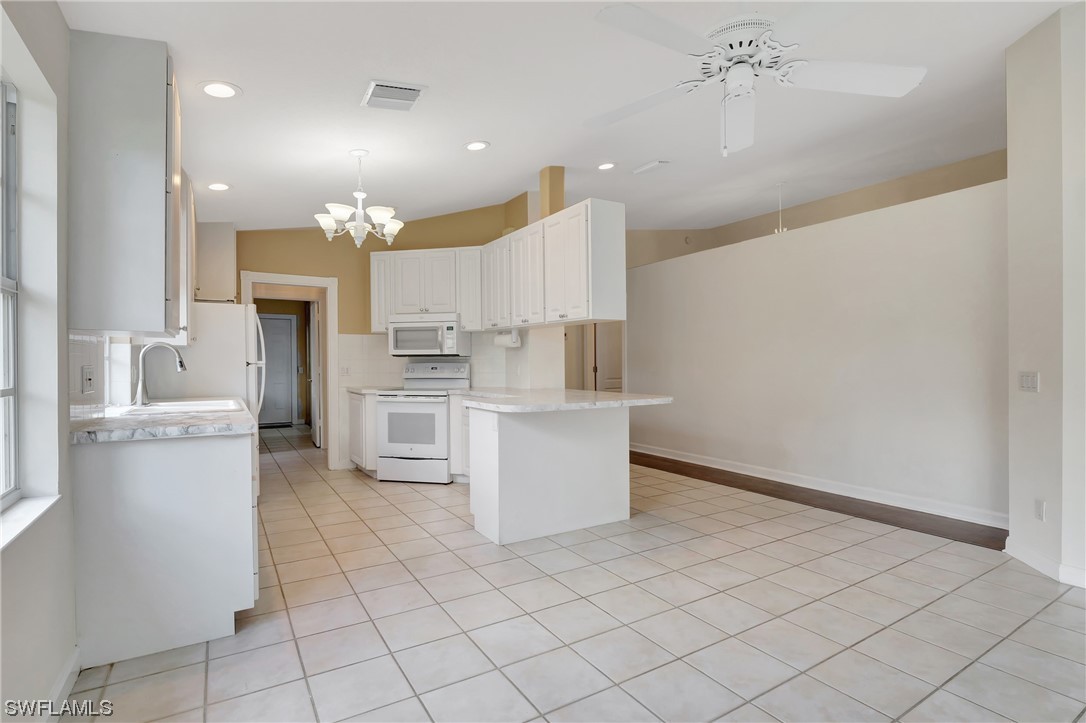 5682 Eleuthera Way Naples, FL 34119 - Photo 15 of 47 a kitchen with a sink cabinets and stainless steel appliances