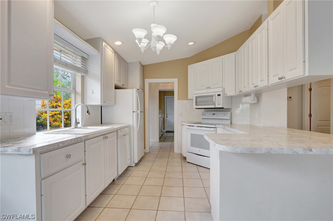 5682 Eleuthera Way Naples, FL 34119 - Photo 16 of 47 a large white kitchen with cabinets