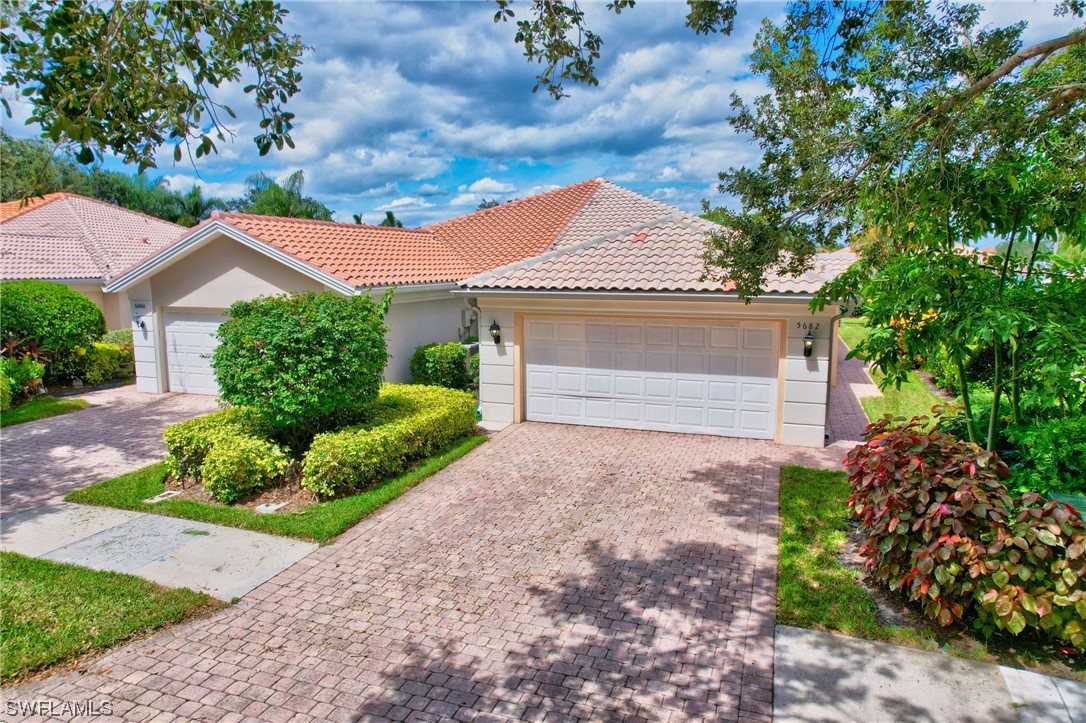 5682 Eleuthera Way Naples, FL 34119 - Photo 25 of 47 a front view of a house with a yard and garage