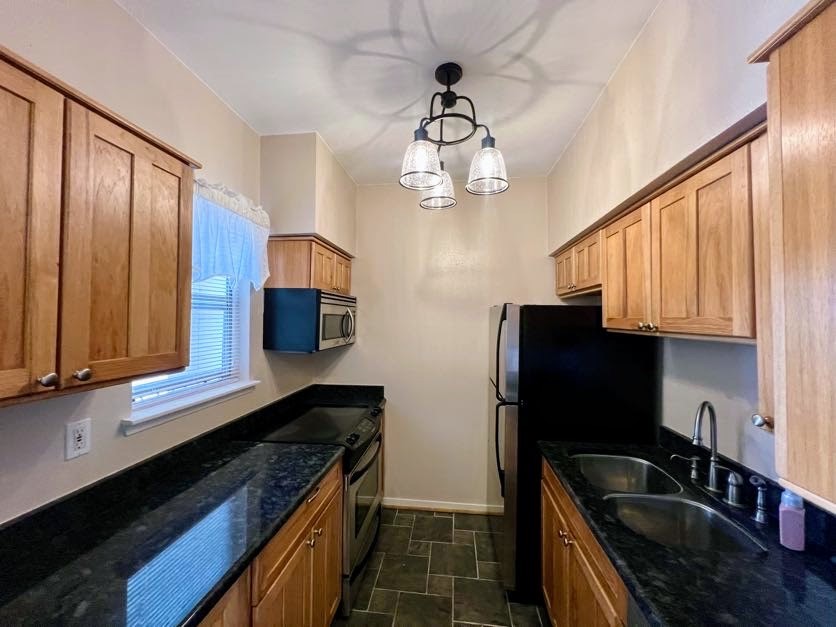 4041 Drake Street, Unit 118 Houston, TX 77005 - Photo 13 of 22 a kitchen with granite countertop stainless steel appliances a sink dishwasher a refrigerator a microwave oven with cabinets and wooden floor
