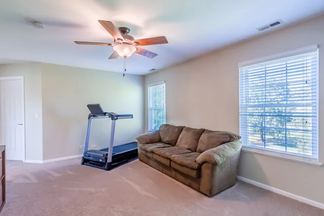 a living room with furniture a ceiling fan and a window