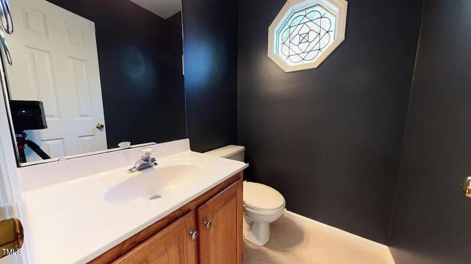 2604 Crofton Springs Drive Raleigh, NC 27615 - Photo 11 of 21 a bathroom with a toilet sink vanity and mirror