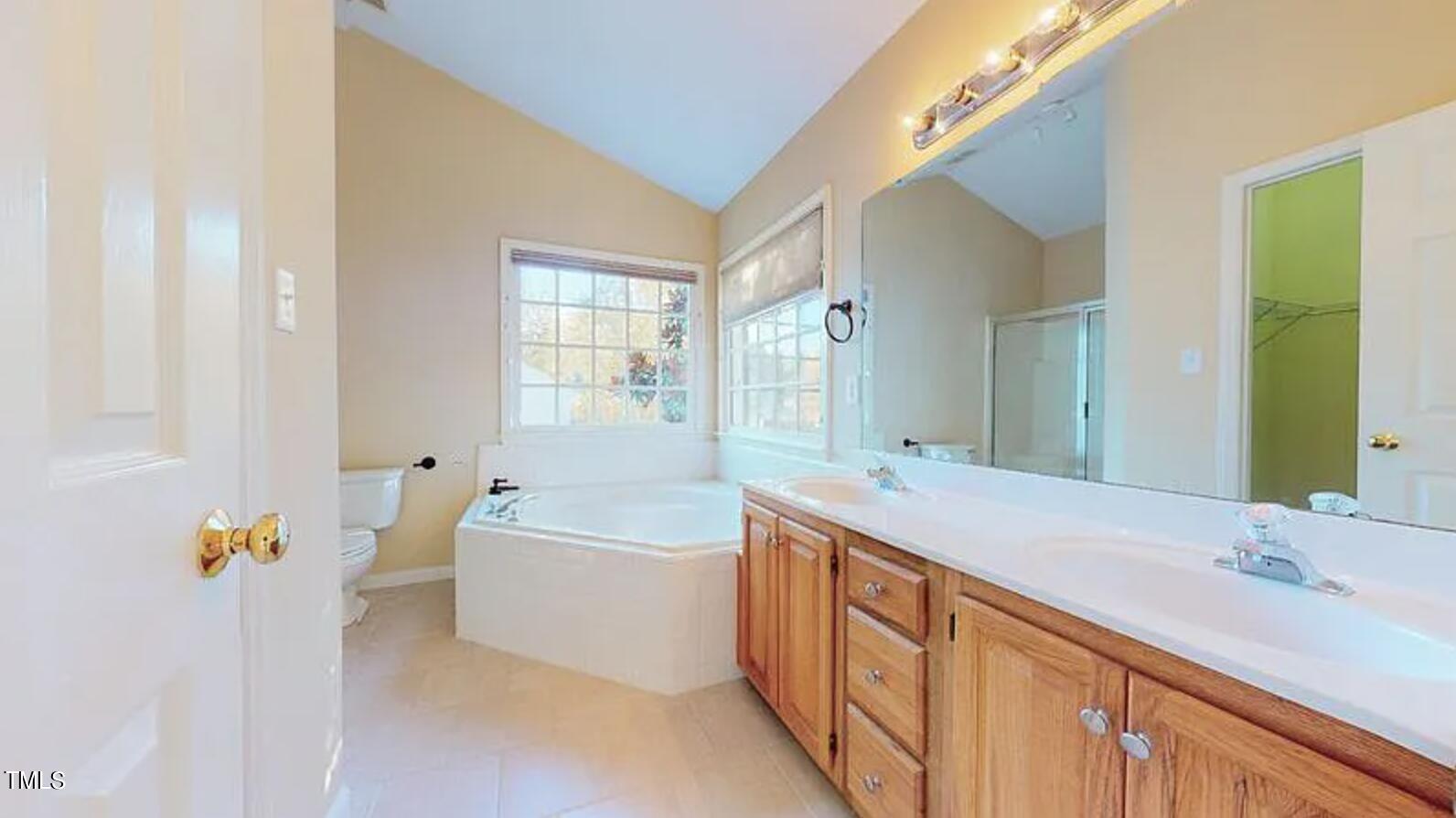 2604 Crofton Springs Drive Raleigh, NC 27615 - Photo 13 of 21 a bathroom with a tub a sink and mirror