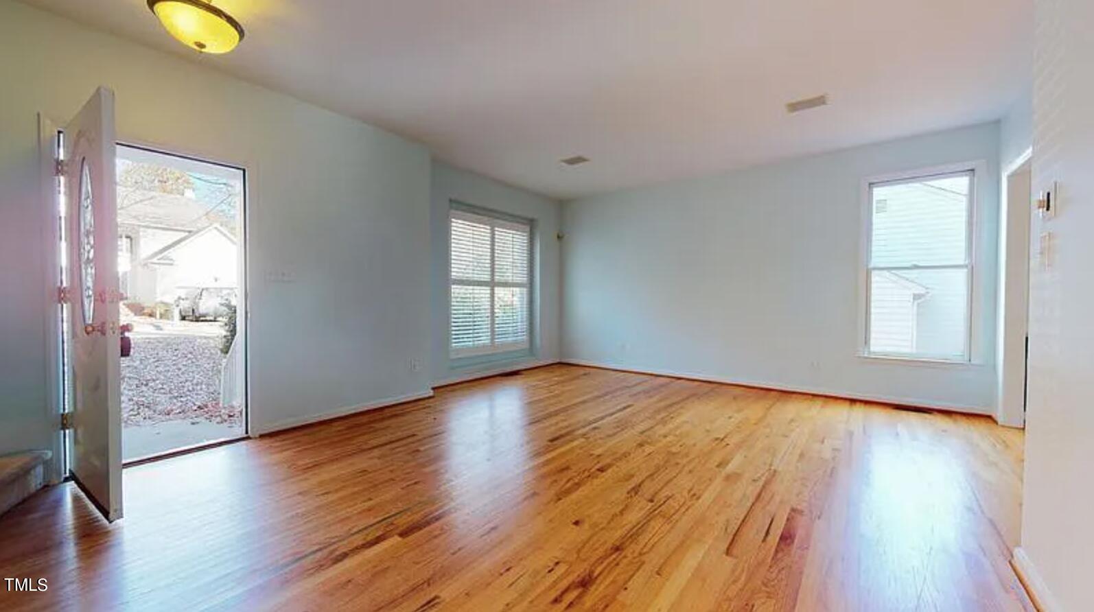 2604 Crofton Springs Drive Raleigh, NC 27615 - Photo 3 of 21 an empty room with wooden floor and windows