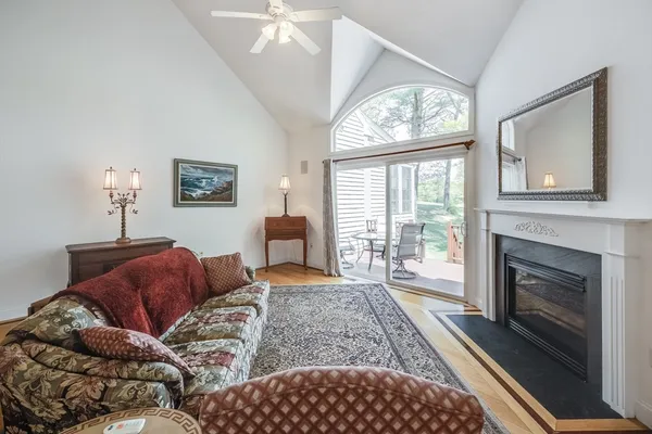 a living room with furniture a large window and a fireplace