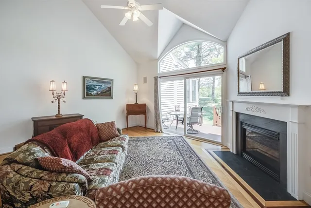 a living room with furniture a large window and a fireplace