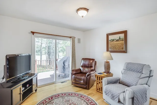 a living room with furniture a flat screen tv and a window