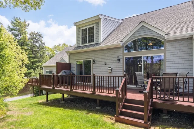 a view of a house with a wooden deck and a yard