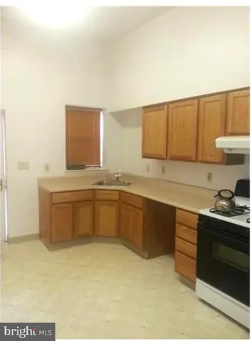 a kitchen with stainless steel appliances a sink stove and cabinets