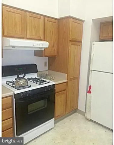 a stove top oven sitting inside of a kitchen
