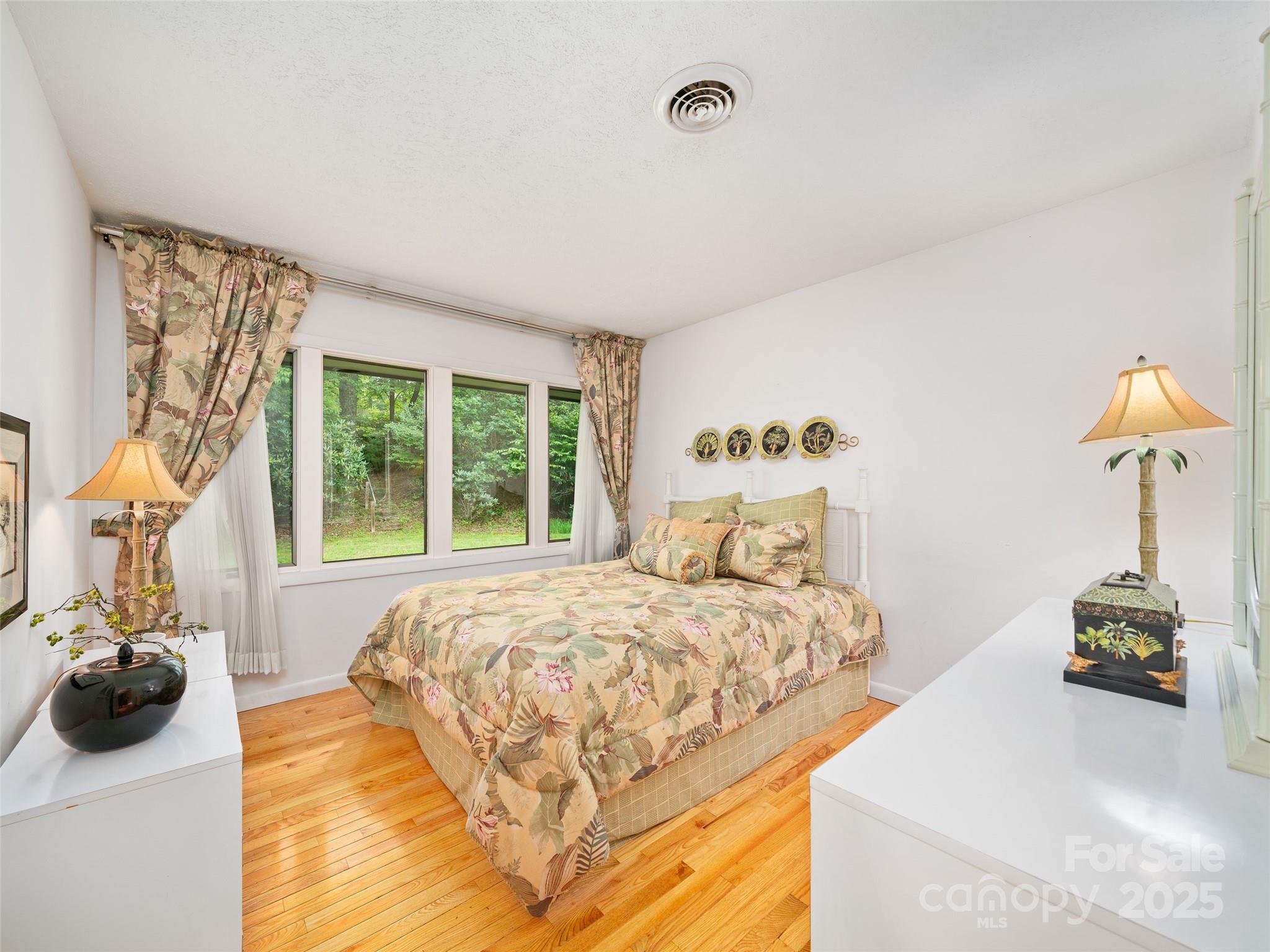 59 Deer Place Road Spruce Pine, NC 28777 - Photo 13 of 40 a bedroom with a bed and a lamp on dresser