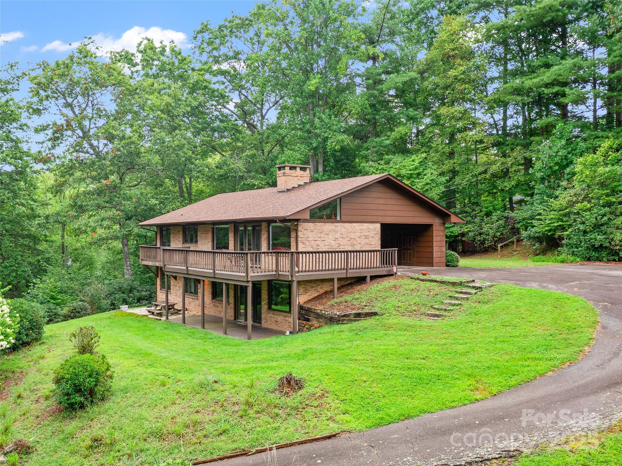 59 Deer Place Road Spruce Pine, NC 28777 - Photo 2 of 40 a view of a house with a big yard and large trees