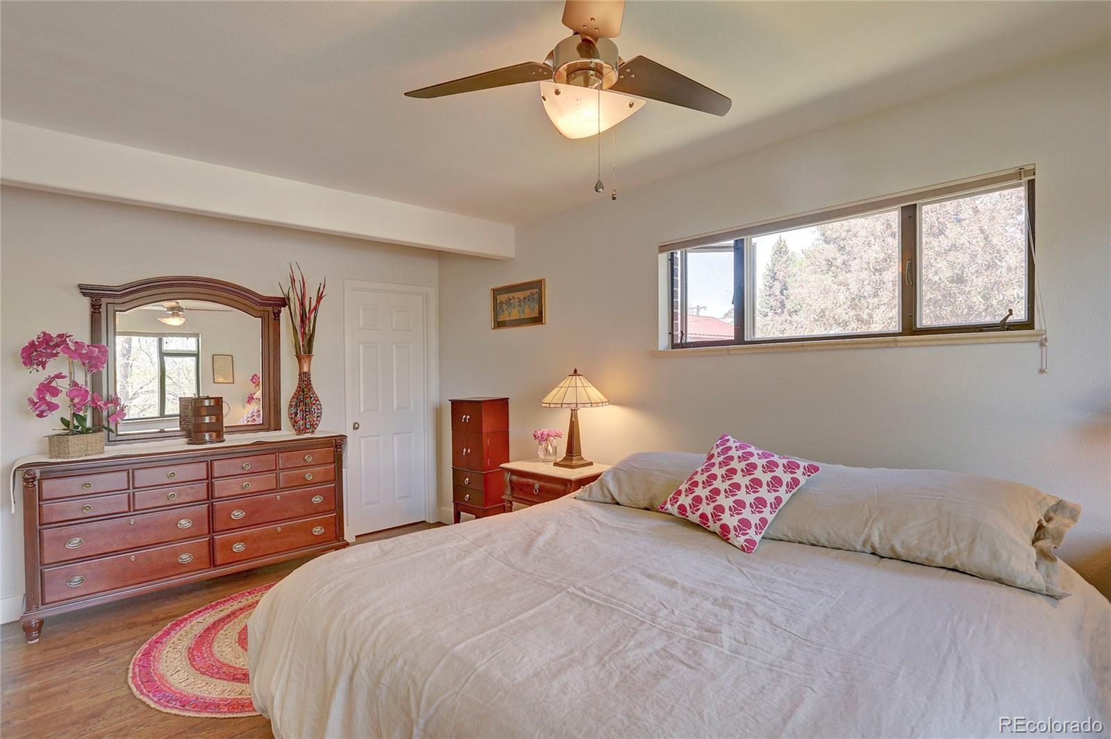 1316 Prairie Road Colorado Springs, CO 80909 - Photo 17 of 30 a bedroom with a bed and wooden floor